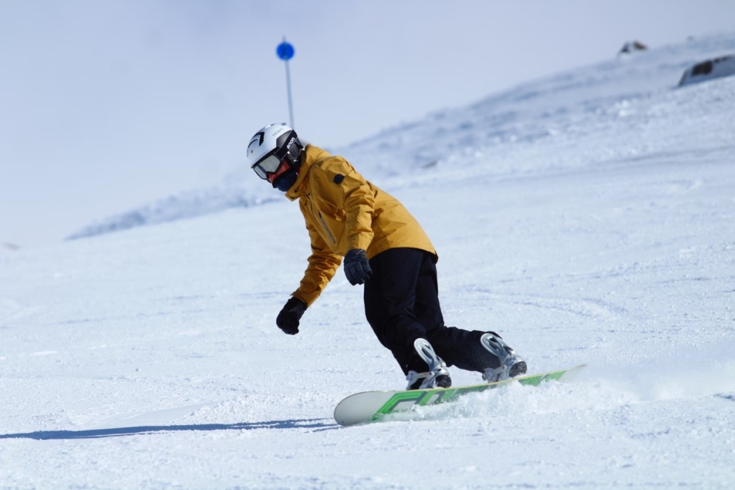 A snowboarder navigates a snowy slope, capturing the excitement of Aspen's top-tier snowboarding trails in the Aspen trails