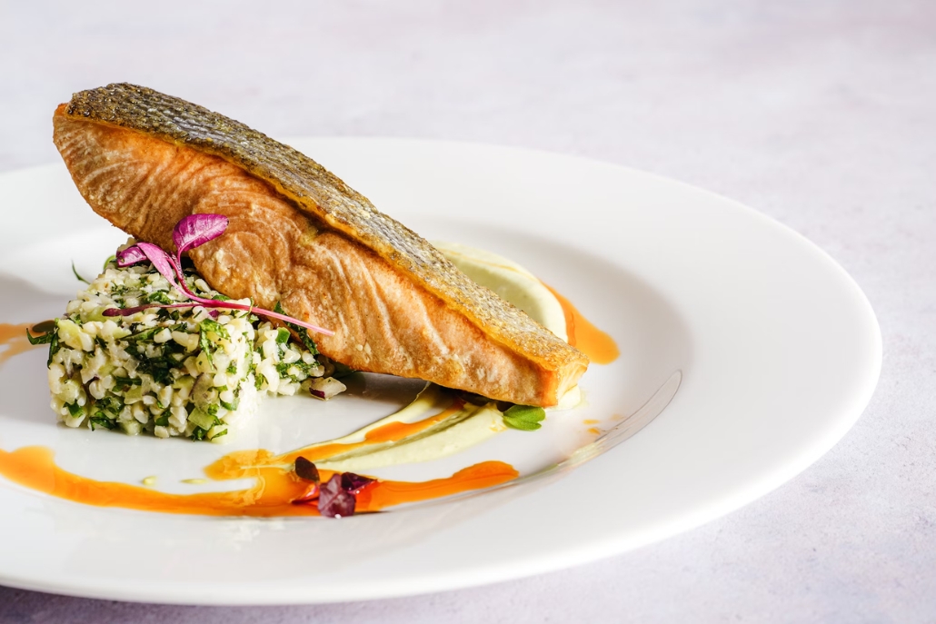 A plate with salmon and rice, complemented by a picturesque Aspen scene in December, showcasing winter beauty.