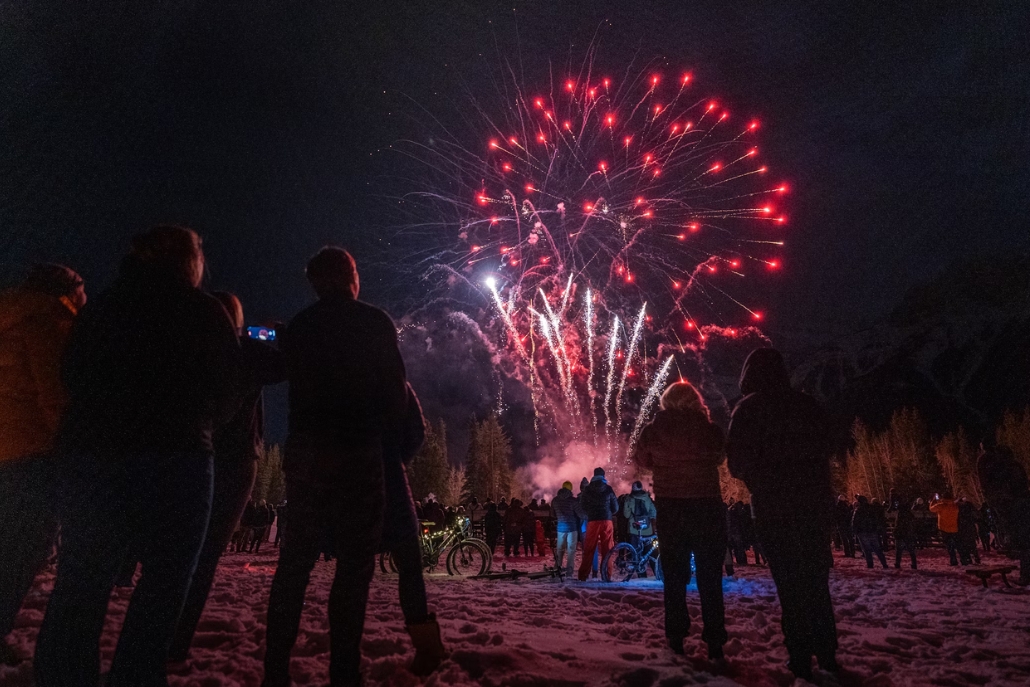 People gather in the snow to enjoy vibrant fireworks at Aspen's Wintersköl celebrations in December.