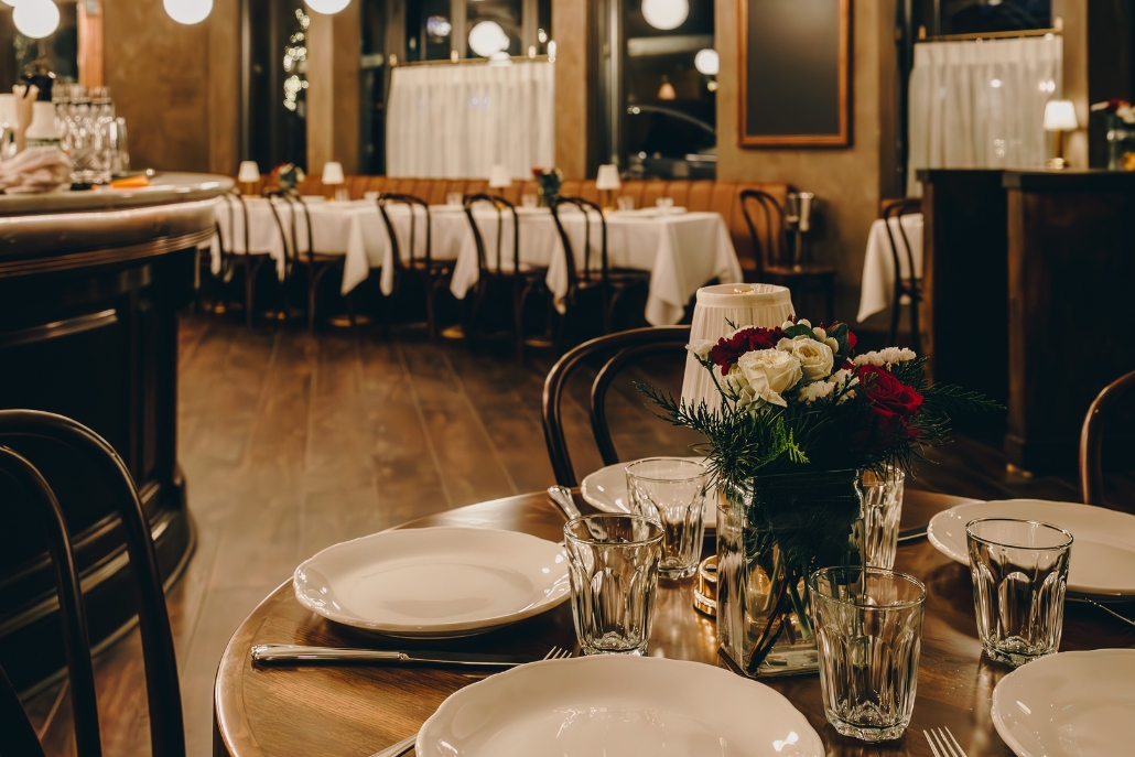 Elegant restaurant table adorned with white plates and place settings, prepared for Thanksgiving festivities in Aspen.