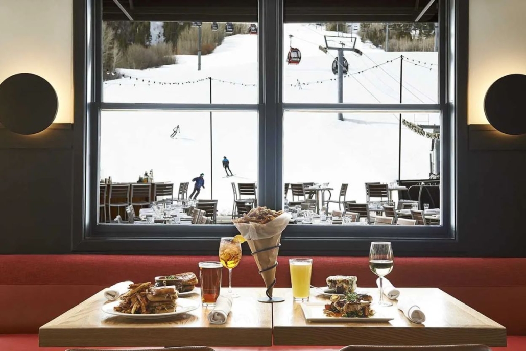 A beautifully set table with gourmet food and drinks serves at Ajax Tavern, perfect for Après-Ski luxury dining.