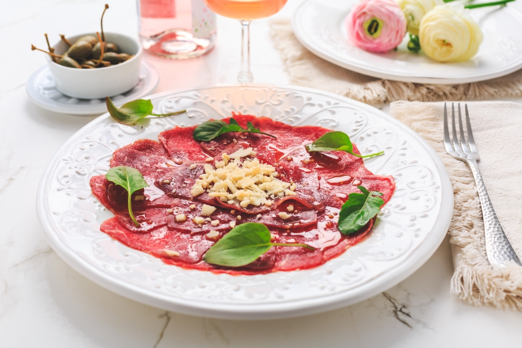 A plate of prime beef tenderloin carpaccio with vegetables, served at Aspen Après-Ski by Casa Tua Aspen.