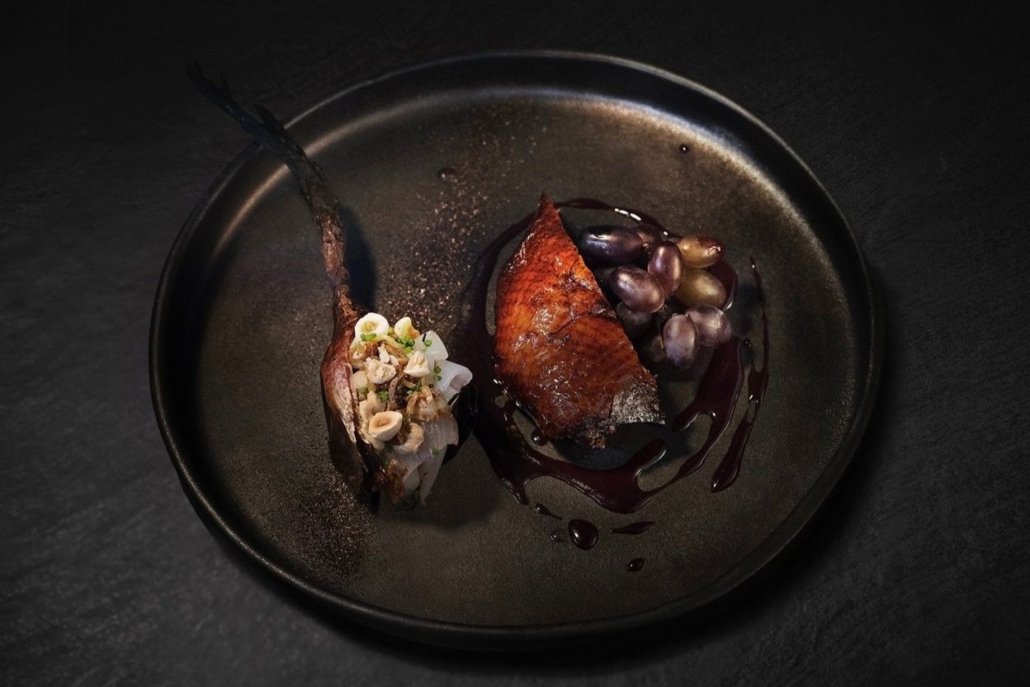 A plate with delicious duck dish, highlighting the culinary experience at Bosq Aspen in February.