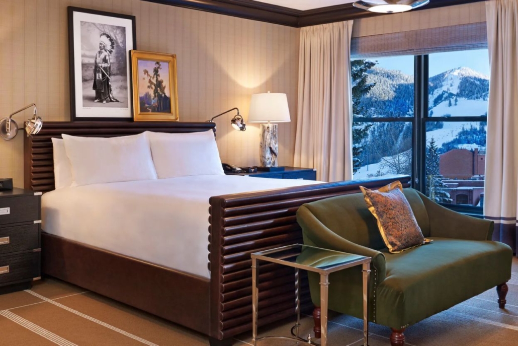 A luxurious hotel room at Hotel Jerome, Aspen, showcasing window with stunning mountain views, perfect for staycation during February. 