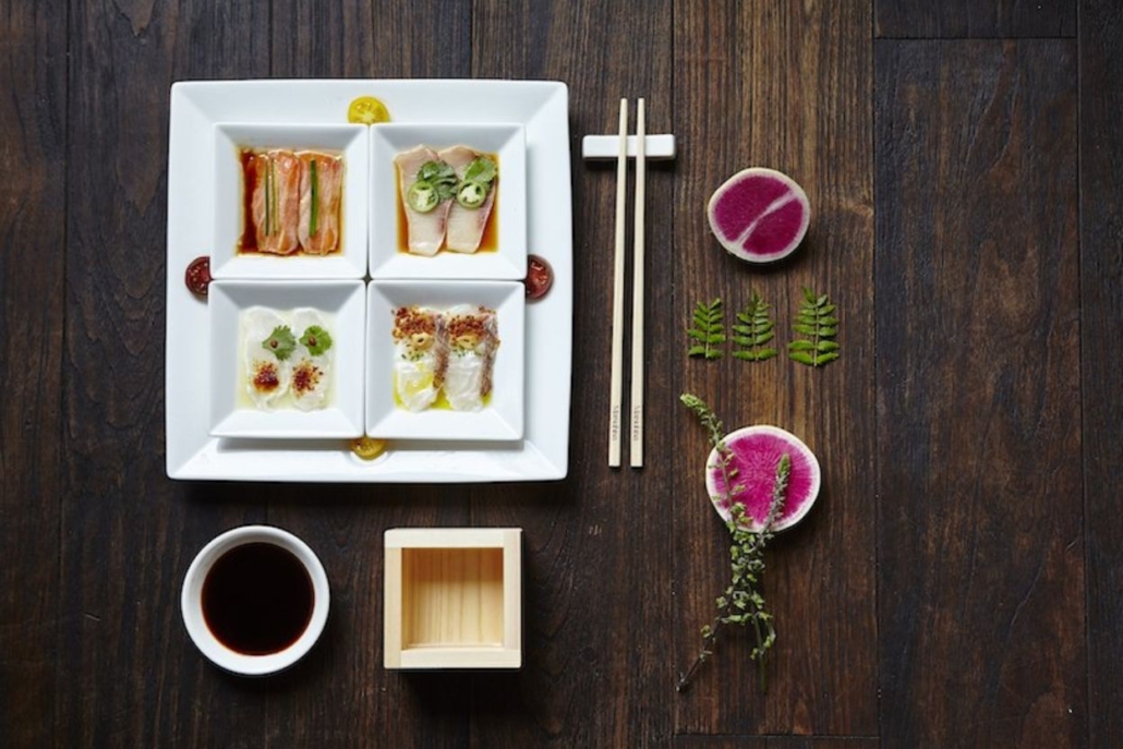 A plate of exquisite food accompanied by chopsticks, elegantly arranged on a wooden table at Matsuhisa Aspen in February.