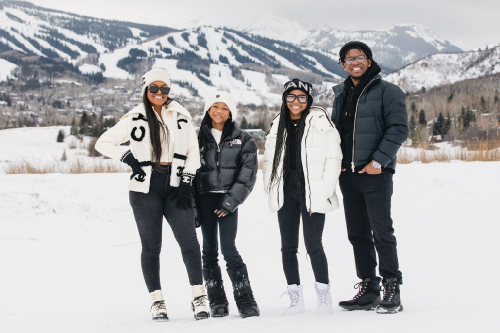 A family group stands in the snow, capturing moments from a winter photography tour.