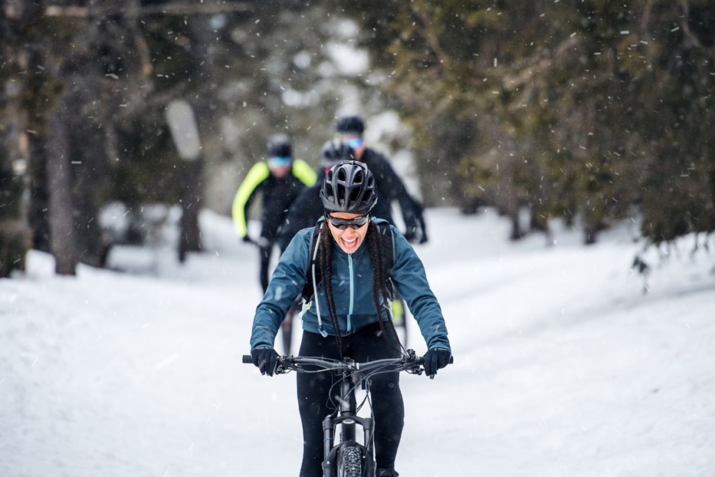 Group of people enjoying a snow biking adventure through a snowy forest in Aspen in January.