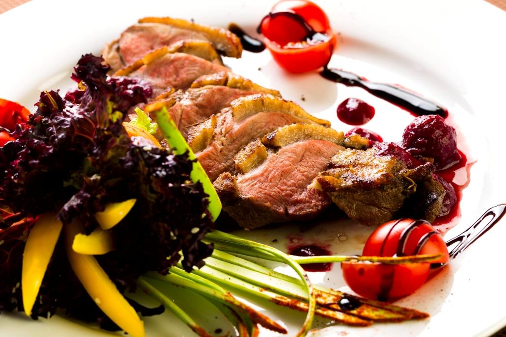A plate featuring duck meat, assorted vegetables, and sauce, served at Bosq in Aspen during February.