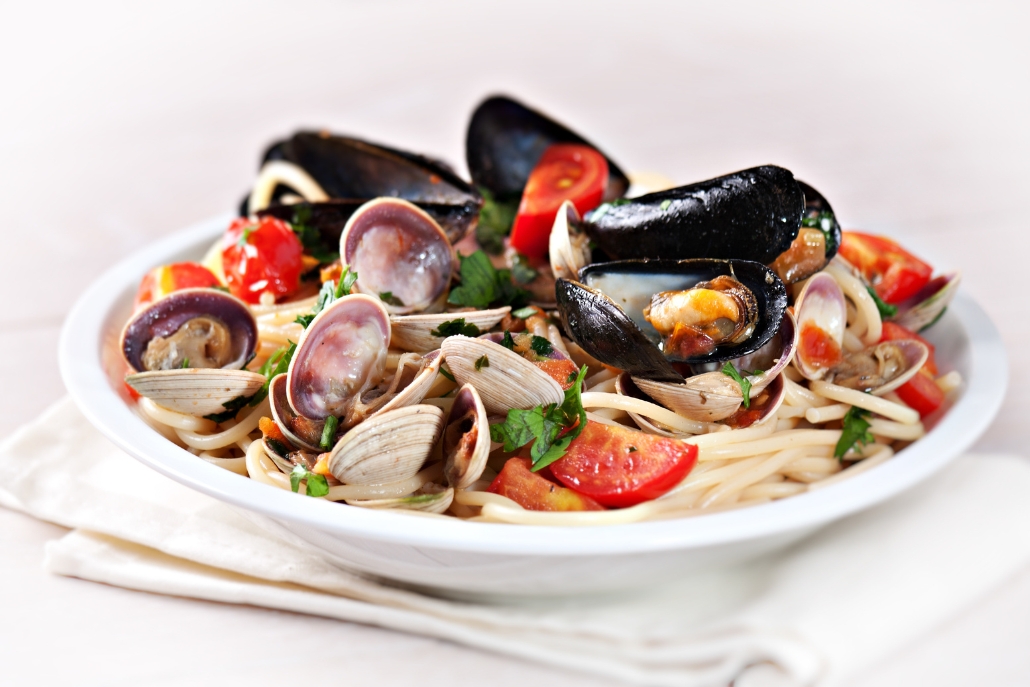 A bowl of pasta with clams and tomatoes, enjoyed at Clark’s Oyster Bar in Aspen, February ambiance.