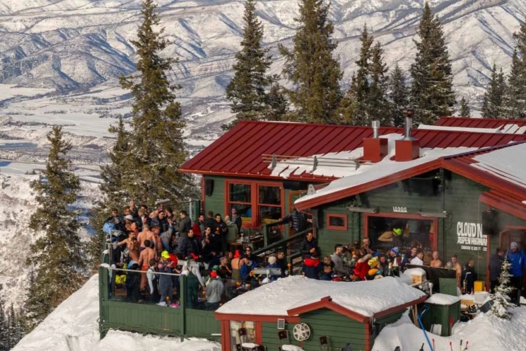 A group of people enjoying après-ski on a snowy slope at Cloud Nine Alpine Bistro in Aspen for a bachelorette celebration.