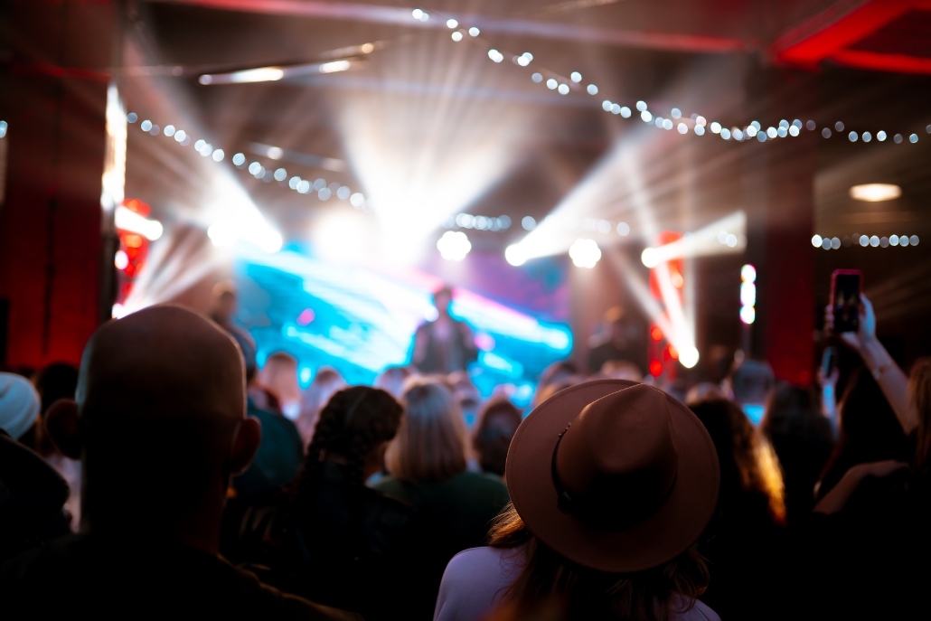 A vibrant crowd at Belly Up concert, surrounded by bright lights, part of the Aspen Bachelorette festivities.