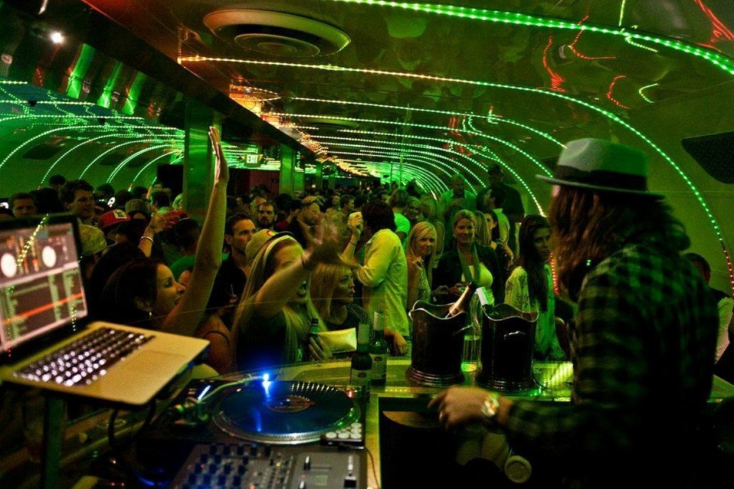 A DJ performs at Escobar nightclub, surrounded by vibrant lights and an energetic crowd. perfect for Aspen bachelorette party.