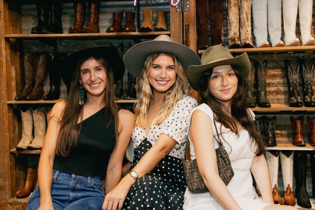 Three women wearing cowboy hats smile for a photo while shopping at Kemo Sabe during an Aspen bachelorette celebration.
