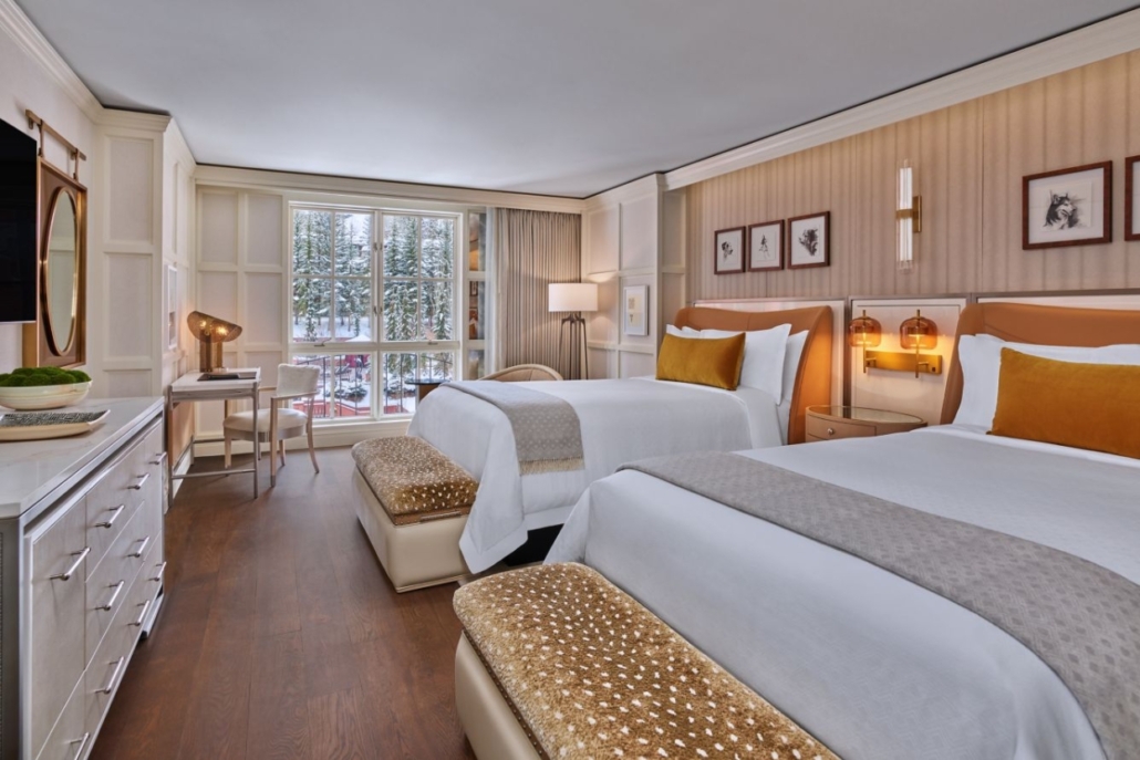 Hotel room at St. Regis Aspen Resort with two beds and a television, perfect for an Aspen bachelorette stays.