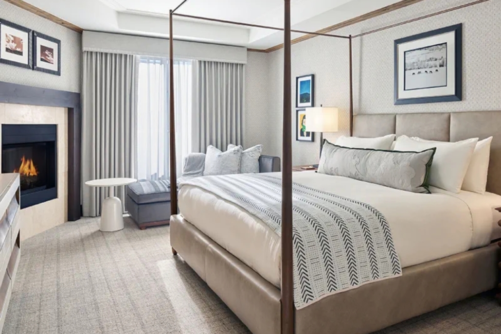 A luxurious hotel room featuring a four-poster bed and a cozy fireplace, designed for an Aspen bachelorette getaway.
