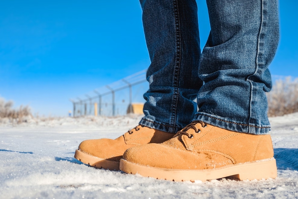 A person in chunky winter boots stands on a snowy ground, highlighting the Aspen style suitable for winter conditions.