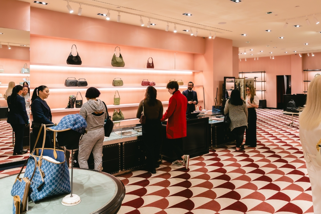 Individuals explore an array of purses in a boutique, highlighting Aspen's summer shopping activities.