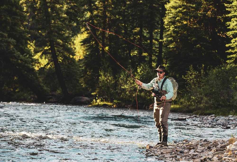 A man fly fishing in aspen in summer