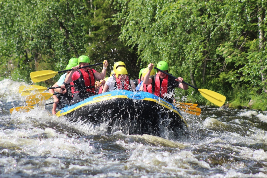 A diverse group of individuals rafting on the Roaring Fork River, showcasing summer activities in Aspen's natural beauty.