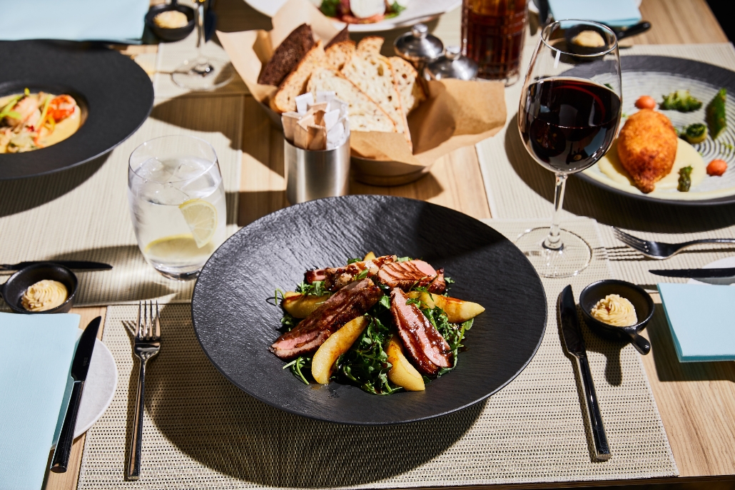 Elegant table adorned with plates of gourmet food and wine, showcasing Aspen's winter culinary delights.