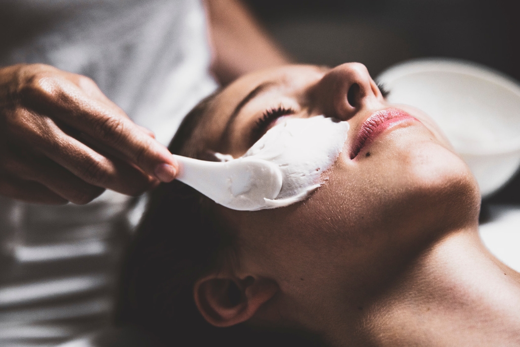 A woman receives a facial treatment with a mask, highlighting a luxury spa experience in Aspen's winter season.