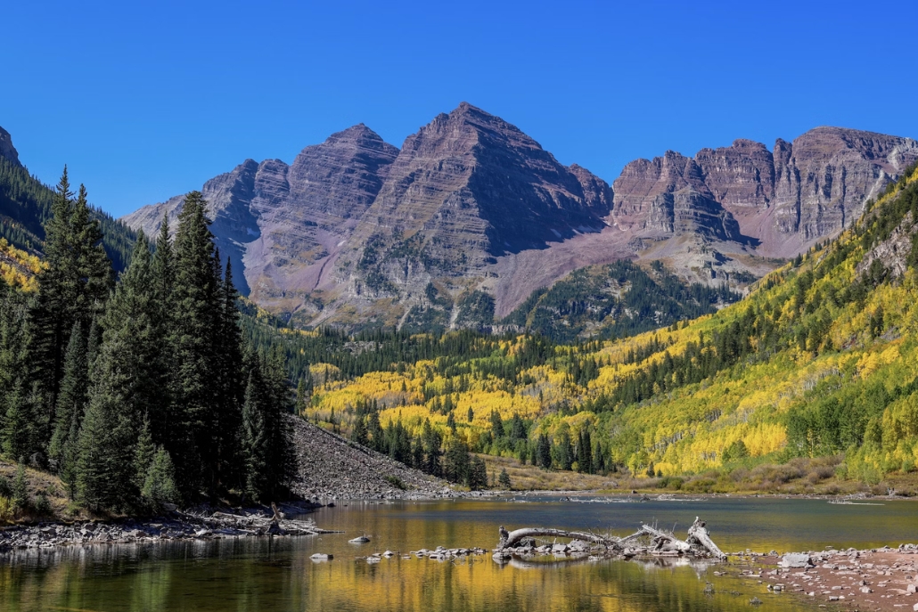 Scenic view of Maroon Bells in Colorado during fall, showcasing vibrant autumn foliage along the hiking trail.