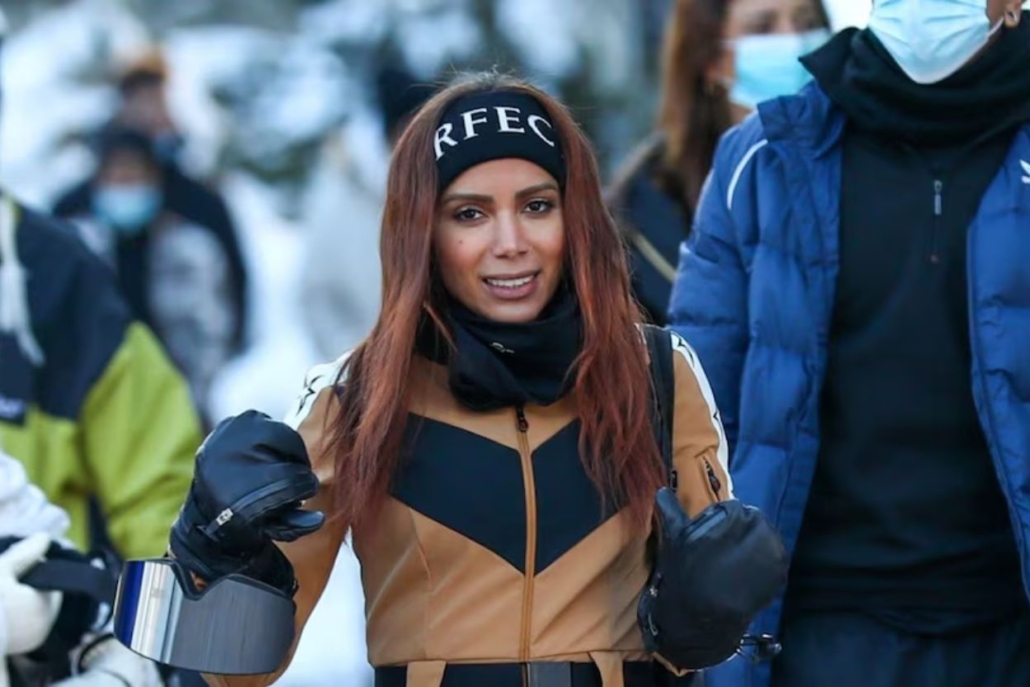 Anitta in a vibrant ski suit and face mask, prepared for skiing in a snowy landscape in Aspen