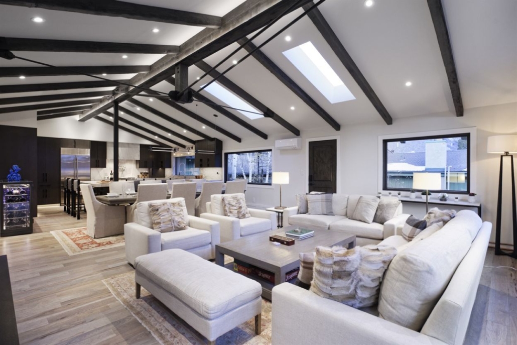 A spacious living room with a vaulted ceiling, connected to a modern kitchen in the Ullr Residence.