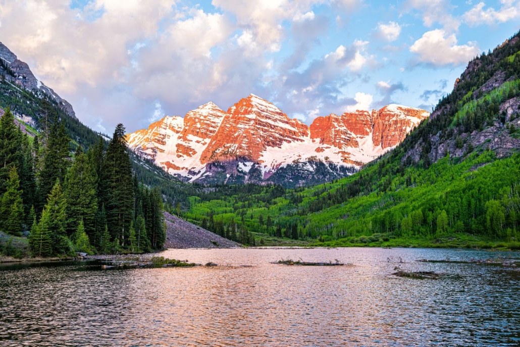 Maroon Bells at sunset in Aspen, with seasonal snow and vibrant greenery highlighting altitude’s visual impact.