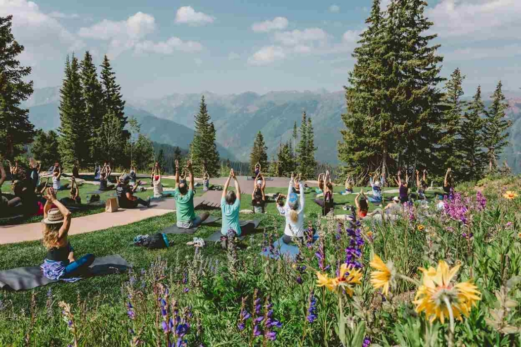 Group yoga session in Aspen’s mountains, promoting wellness and altitude adjustment through mindful breathing.