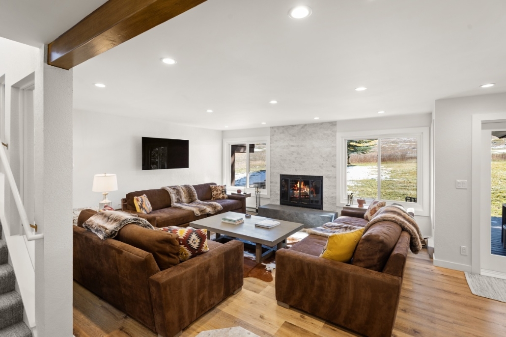 Cozy living room featuring a fireplace and couches, set in an Aspen fall-themed Country Club Townhome.
