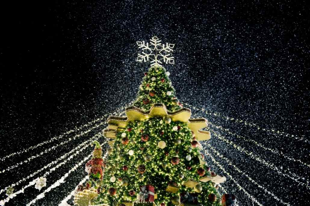 A beautifully lit Christmas tree shines at night, celebrating the holiday spirit during Aspen, Colorado's tree lighting ceremony.