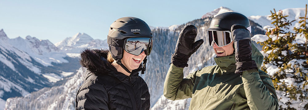A couple on a snowy mountain, enjoying their romantic honeymoon in Aspen.