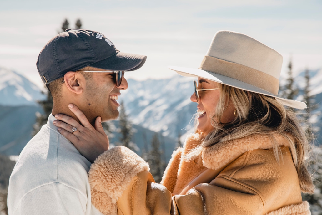 A couple shares a romantic moment in a snowy Aspen setting, celebrating their engagement during a winter session.