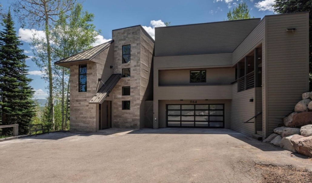 Modern mountain home surrounded by trees at Faraway Escape in secluded Snowmass, featuring minimalist architecture and a private driveway.