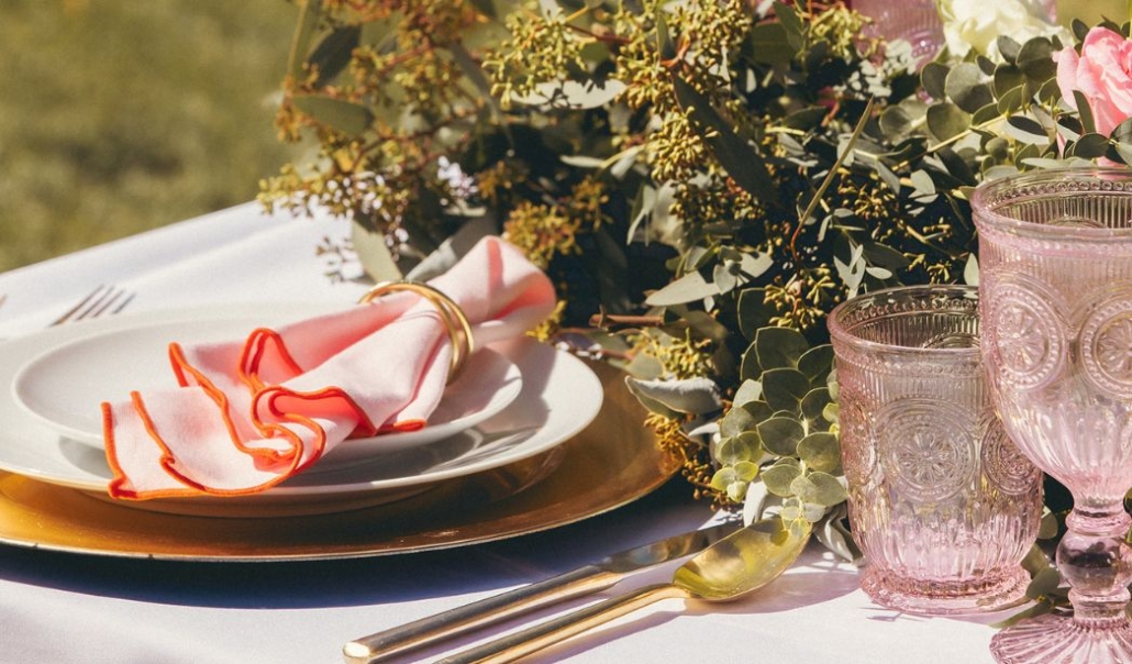 Elegant Thanksgiving table setting with gold utensils, pink glassware, and a floral centerpiece, styled for an outdoor Aspen Thanksgiving celebration.