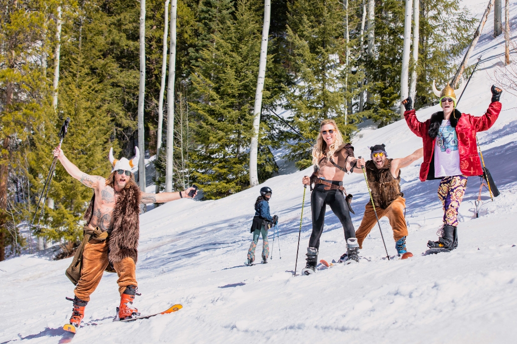 A lively group of people skiing together during Aspen Gay Ski Week, celebrating inclusivity and winter fun.