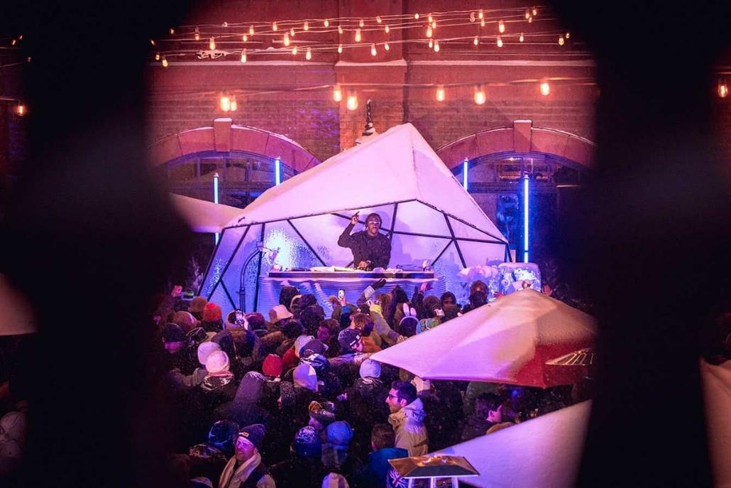 Guests dancing and celebrating under colorful lights at Aspen Gay Ski Week’s Themed Late Night Parties, enjoying music, costumes, and a vibrant nightlife atmosphere.