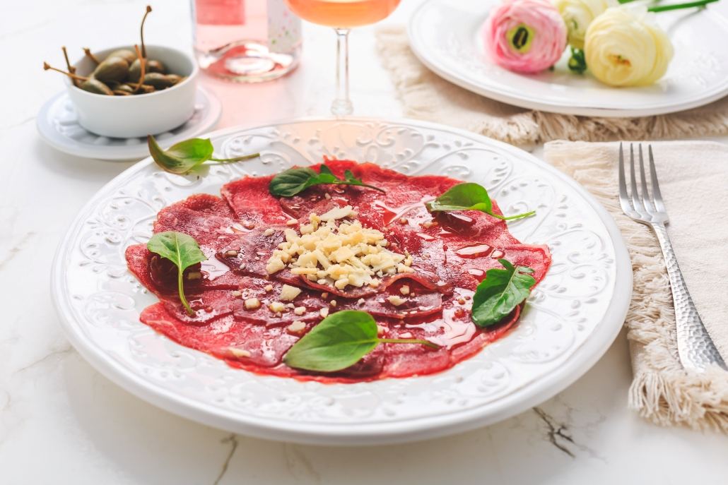 A plate of prime beef tenderloin carpaccio with vegetables, served at Aspen Après-Ski by Casa Tua Aspen.
