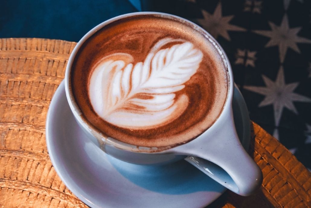 A coffee cup with a leaf design on the surface, included in the Aspen Itinerary for enjoying a big breakfast.