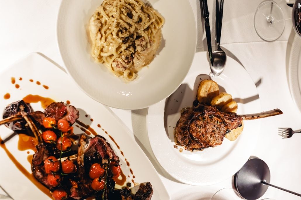 An elegant dining table in Aspen with an array of food plates and wine glasses, set for a private dining experience.