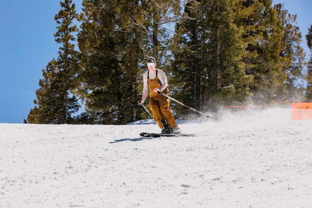 A person skillfully skis down a snowy slope, capturing the thrill of skiing at Aspen Mountain on Day 2 of the itinerary.