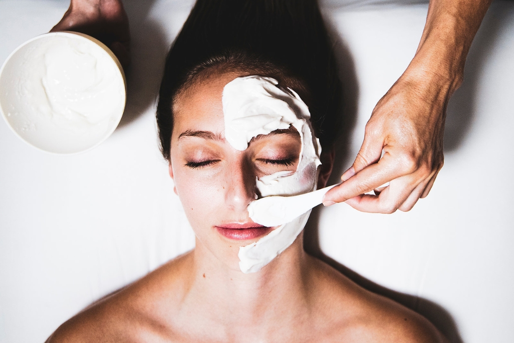 A woman receives a facial mask treatment at a luxury spa in Aspen, highlighting relaxation and wellness in a tranquil setting.