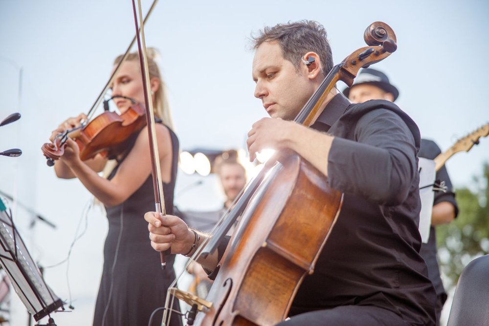 Musicians performing at the Aspen Music Festival with violin and cello on an outdoor stage