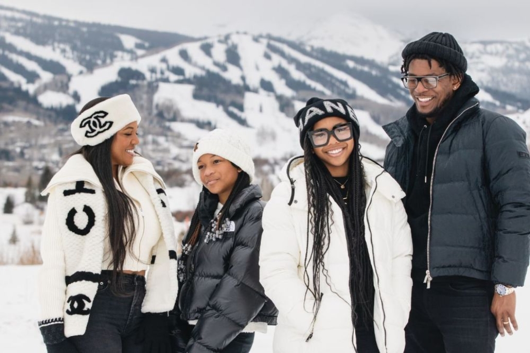 Family enjoying a winter day in Aspen Colorado with snowy mountains and ski slopes in the background