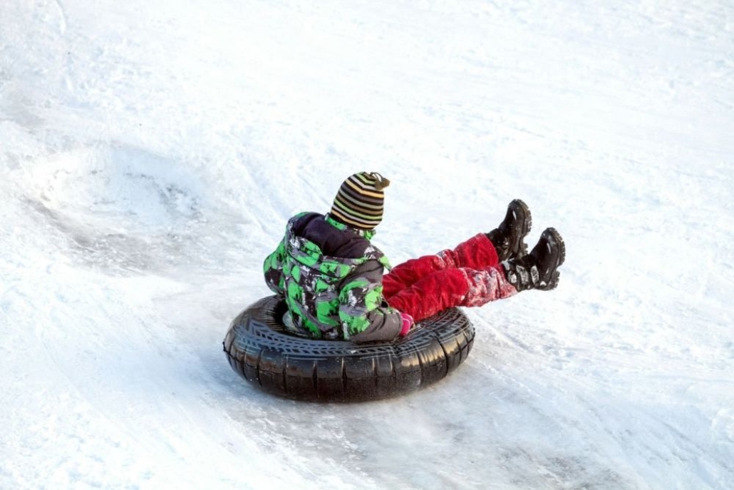 Child snow tubing in Aspen Colorado during a fun winter family vacation activity on snowy slopes